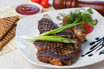 grilled beef steak with sauce and vegetables on a white plate