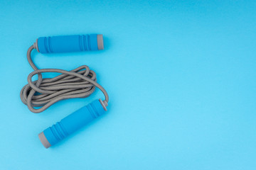 Skipping rope or jumping rope isolated on blue background. Selective focus and crop fragment