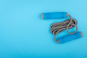 Skipping rope or jumping rope isolated on blue background. Selective focus and crop fragment