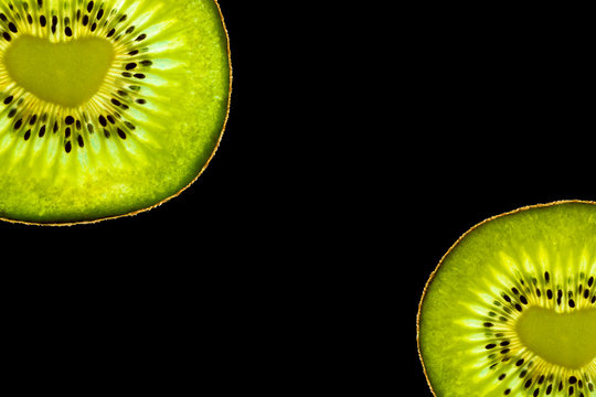 Сopy space with two isolated kiwi fruit with a heart-shaped core on black background