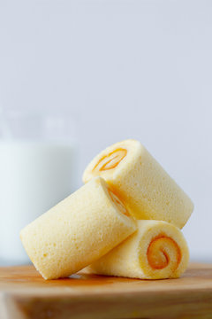 Yamroll cake on wood tray with milk background