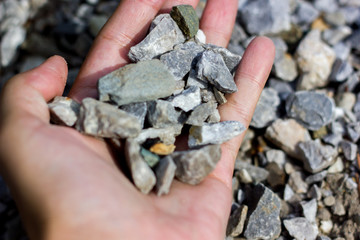 Stone rock background texture, gray stone road. Rubble, macadad background texture close up. Natural environmental background texture. Rubble stones in hand, soft focus, close-up.