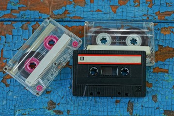 three old audio tapes are on the blue board