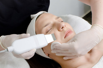 Beautiful woman receiving ultrasonic facial exfoliation procedure of ultrasonic cleaning of face in beauty salon.Modern Ultrasonic skin equipment for ultrapeel treatment 