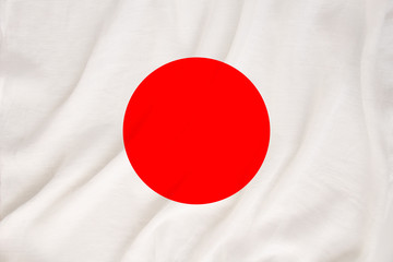 The national flag of the country of Japan on the gentle silk with the folds of the wind, the concept of travel, immigration, politics