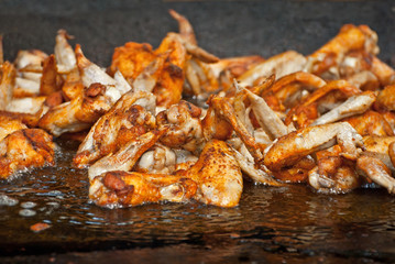 Slice pieces of meat on the grill. barbecue at the festival. Chicken fryer