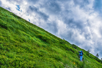 Traveler with a backpack. Mountain landscape with beautiful clouds. Ukraine. Carpathians. Travels. Hiking.