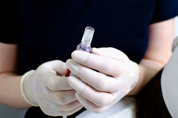 beautician in white gloves holding dermis stamp electric pen, dermapen tool for needle mesotherapy...