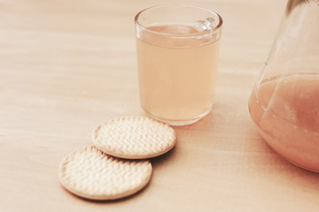 Break time for childen. Tasty cookies with orange juice on the wooden table.