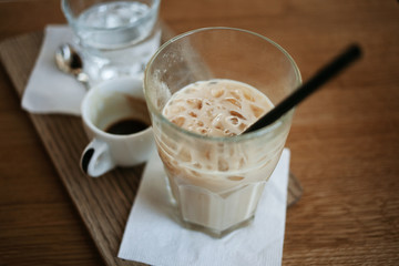 Coffee time concept. A cup of espresso and a glass of ice latte standing near each other. Close up. View from above.