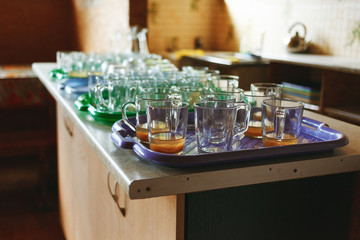 Stacks of cups of finished meal after lunch waiting to clean at the dining room in camp.