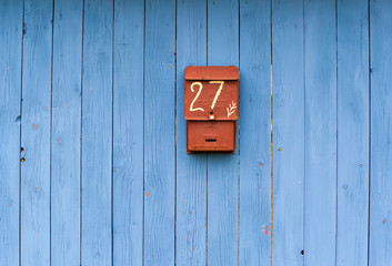 blue wooden fence with mailbox in the foreground