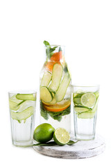 Natural lemonade with orange,lime, cucumber and mint in bottle isolated on white background. Detox water for a healthy lifestyle.