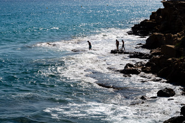 Menschen am Strand bei Gegenlicht