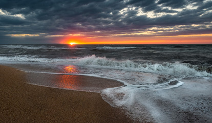Stormy sea at sunset time, empty beach