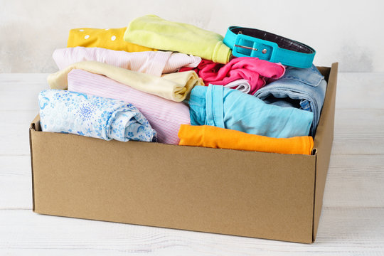 Various colorful clothes in a box for shipping or donation.
