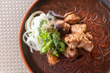 pieces of shashlik with ketchup and onions on a plate
