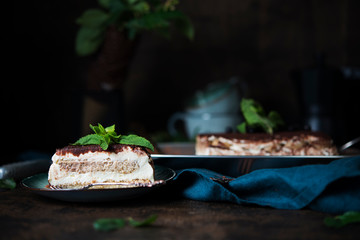 Homemade tiramisu cake with cocoa on a dark background. Traditional Italian dessert.