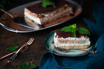 Homemade tiramisu cake with cocoa on a dark background. Traditional Italian dessert.