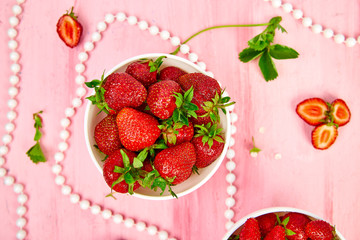 Ripe red strawberries on pink table, Strawberries in white bowls. Fresh strawberries. Beautiful strawberries. Diet food. Healthy, vegan. Top view. Flat lay.
