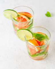 Glass of cool infused water with fresh grapefruit, lime and mint, (lemonade, cocktail). Detox drink, health care, fitness, diet concept.
