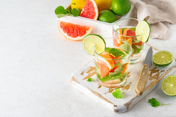 Glass of cool infused water with fresh grapefruit, lime and mint, (lemonade, cocktail). Detox drink, health care, fitness, diet concept.