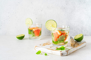 Glass of cool infused water with fresh grapefruit, lime and mint, (lemonade, cocktail). Detox drink, health care, fitness, diet concept.