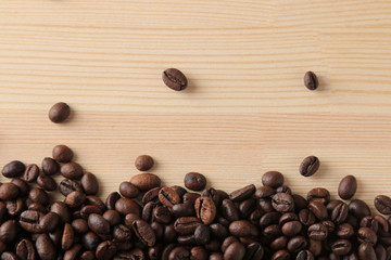roasted coffee beans on a natural wooden table. Frame of coffee beans Robusta, Arabica. top view. space for text