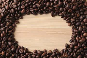 roasted coffee beans on a natural wooden table. Frame of coffee beans Robusta, Arabica. top view. space for text