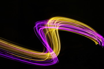Long exposure light painting photography, curvy lines of vibrant neon pink purple and metallic...