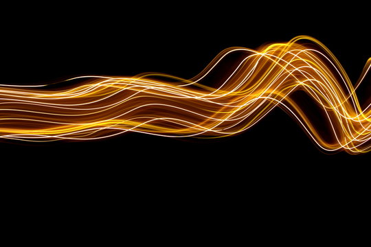Long exposure light painting photography, curvy lines of vibrant neon metallic yellow gold against a black background