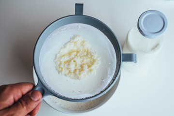 Close up of kefir grains being strained.