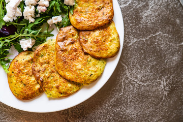 Pancakes with greek salad on white plate
