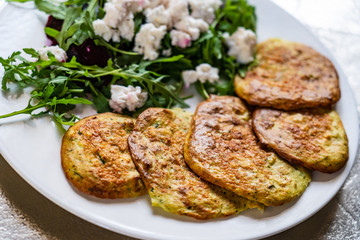 Pancakes with greek salad on white plate