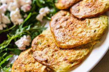Pancakes with greek salad on white plate
