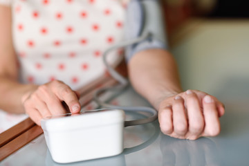 Fototapeta na wymiar Woman measuring her own blood pressure at home.