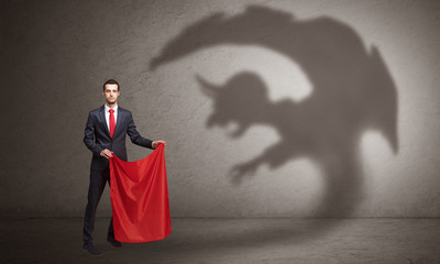 Businessman standing with red cloth in his hand and imp shadow on the background