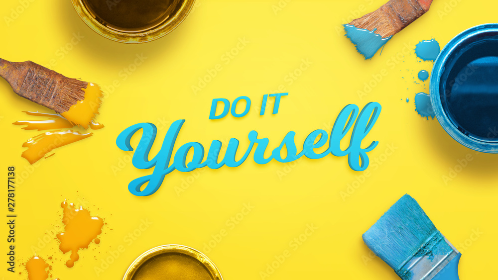Poster Do it yourself text surrounded with color brushes and boxes and a few drops of color on yellow surface.