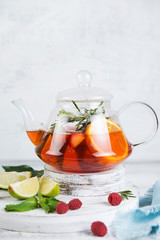 Summer tea in a kettle of fresh fruit and berries. Natural berry tea light background.