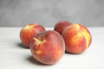 Fototapeta na wymiar Fresh juicy peaches on white wooden table