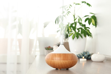 Composition with modern essential oil diffuser on wooden shelf indoors, space for text