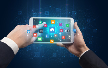 Hand using tablet with colorful bounce application symbols and icons concept