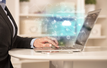 Business woman in homey environment using laptop with cloud technology concept