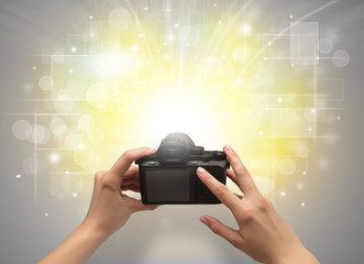 Naked hand taking picture with digital camera and glowing flash concept