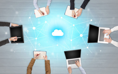 Group of people with devices in hands working in team on tablets, laptops with application concept