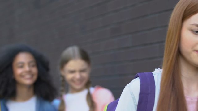 Teen girl ignoring mockery of classmates, resisting bullying, inner strengths