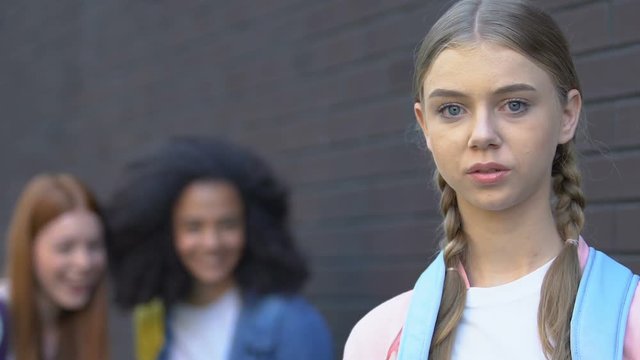 Poor pale teenage girl suffering bullying from rich peers, wealth inequality