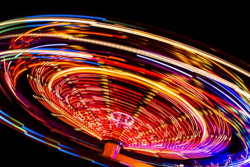 an illuminated carousel at the fun fair at night © dieterjaeschkephotos