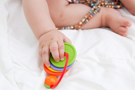 Color Toy In The Hand Of The Baby - The Development Of Fine Motor Skills In Children