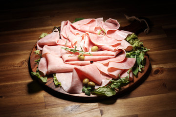 Sliced ham on wooden background. Fresh prosciutto. Pork ham proscuitto sliced.